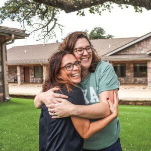 VSN Program Director, Hannah O'Brien, hugs peer leader at 2023 leader retreat